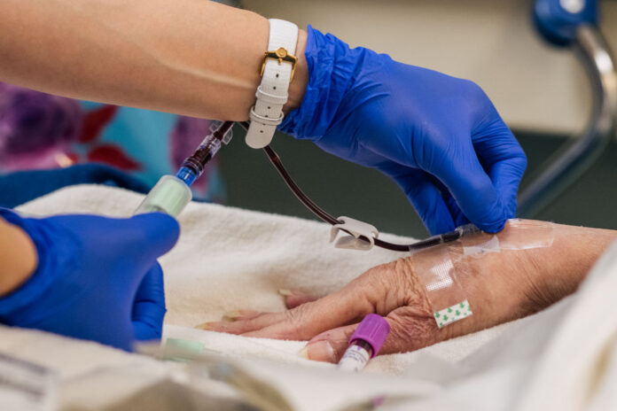 A physician administering care. (Photo by Brandon Bell/Getty Images)