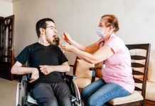 New law will enhance emergency response for people with disabilities A caregiver feeds a disabled man in a wheelchair. (Photo by Getty Images)